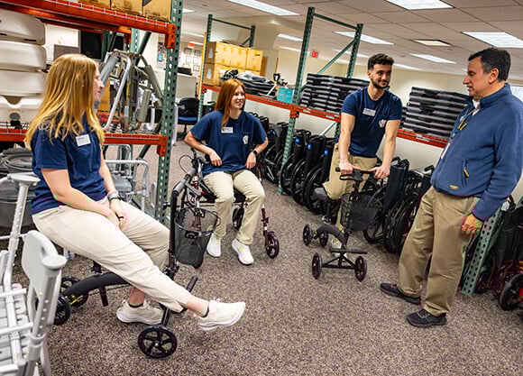 Students learning with durable medical equipment at the Wheel It Forward site