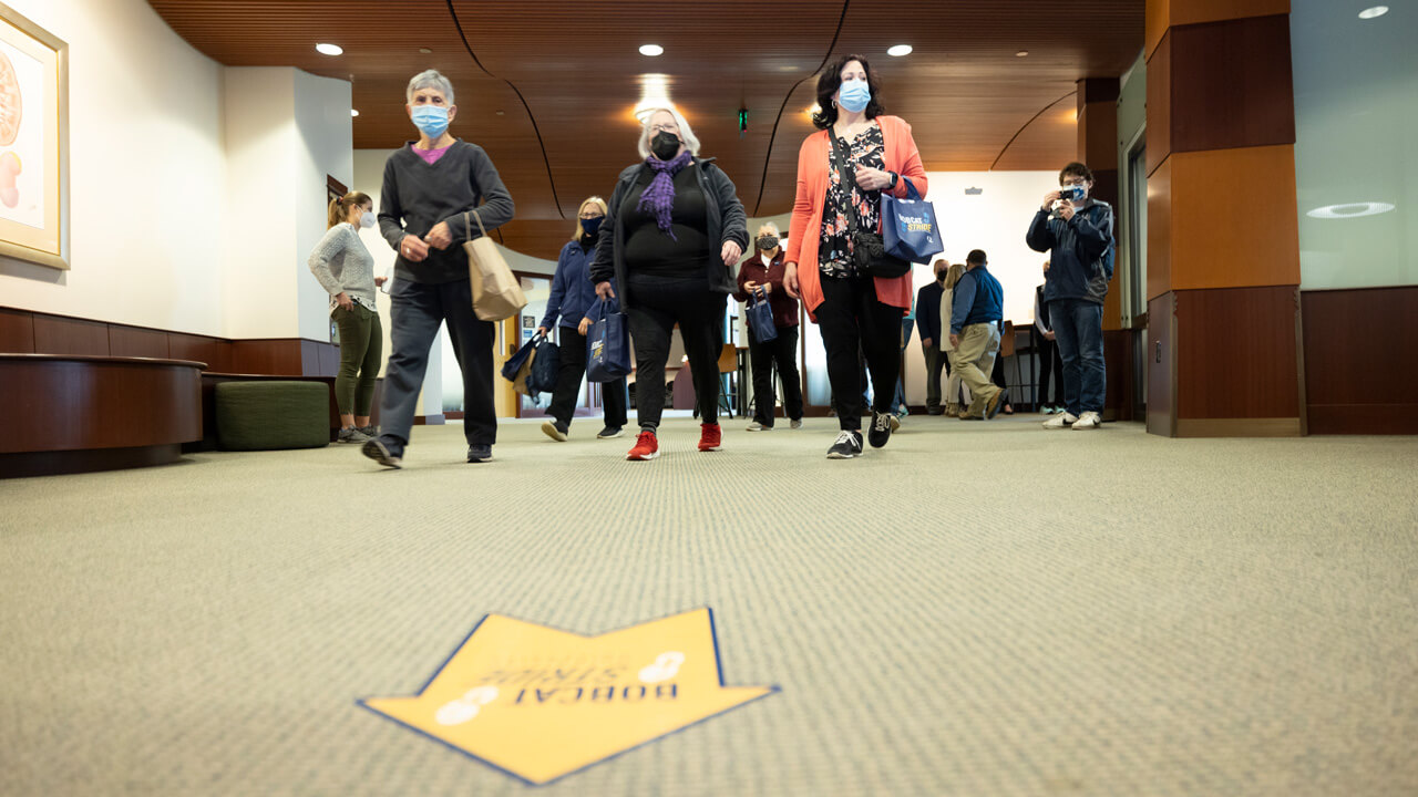 A group of older adults walking through a hallway