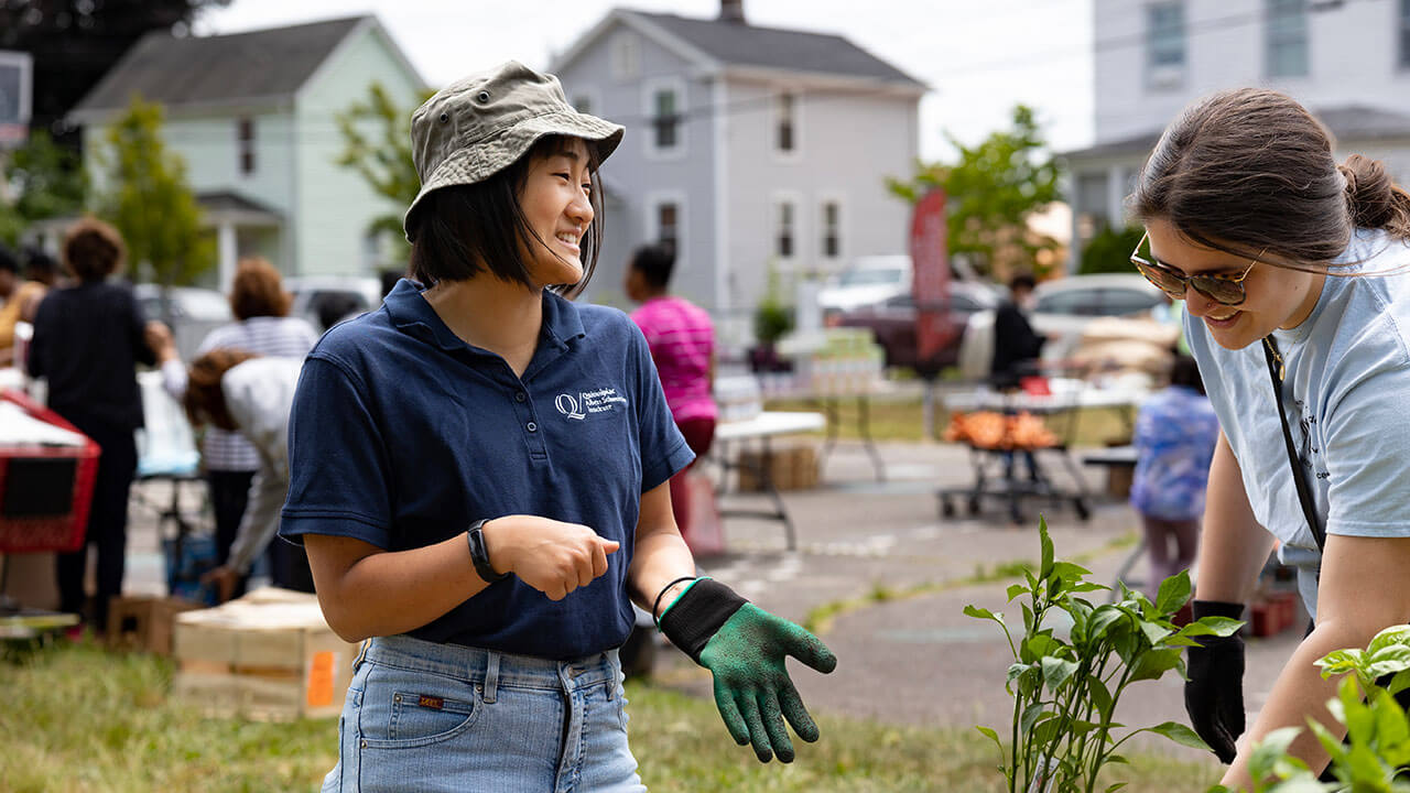 Two students happily talking while planting