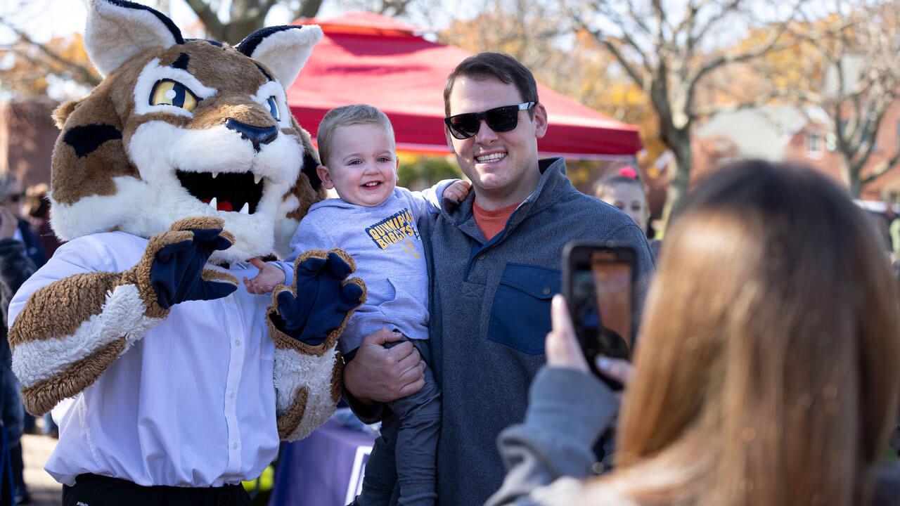 Baby smiling and laughing posing for a photo with Boomer