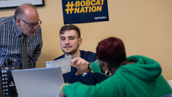 A finance student and professor assist a Hamden resident with her tax forms