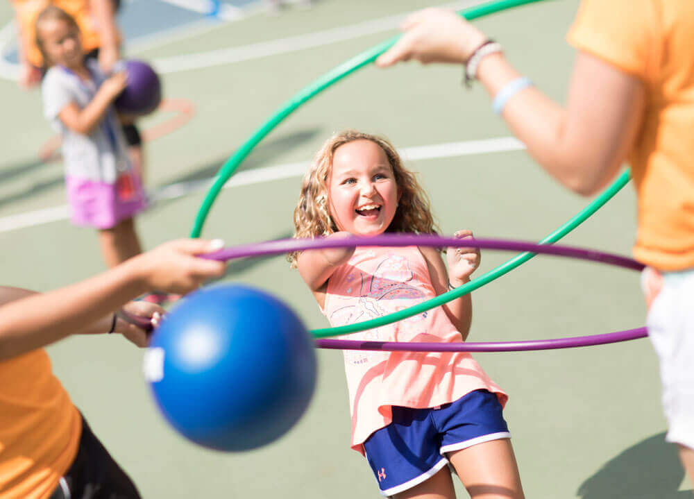 Young girl with amputated arms plays a game with a Quinnipiac student